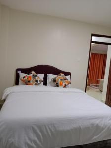 a large white bed with two pillows on it at Mimos 2 BR Machakos in Machakos