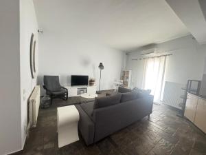 a living room with a couch and a tv at Beachfront ! in Amarynthos
