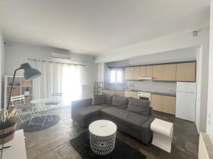 a living room with a couch and a kitchen at Beachfront ! in Amarynthos