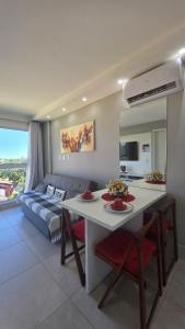 a living room with a table and a couch at Aline Duque 308 no Centro de Porto by La Playa in Porto De Galinhas
