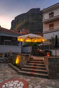 カランバカにあるNF Meteora Residenceの傘、テーブル、椅子が備わる建物