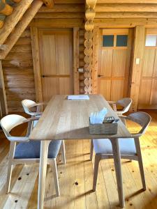 a table and chairs in a room with a log cabin at wood house in Hita +21 photos