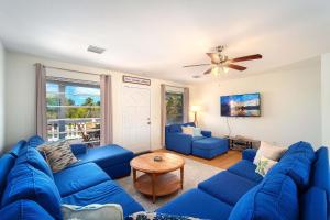 a living room with blue couches and a ceiling fan at Our Happy Place in Sugarloaf Shores