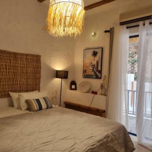 a bedroom with a large bed and a chandelier at BF Blue Cactus in Agia Pelagia +50 photos