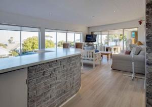 赫曼努斯Corner Delight at Onrust Beach的厨房以及带砖墙的起居室。