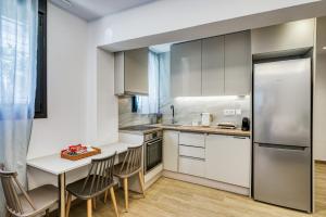 a kitchen with white cabinets and a table and chairs at Virginia Haven 2 in Chios +17 photos