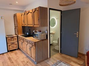 a kitchen with a microwave on top of a counter at La Datcha in Saint-Appolinaire