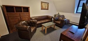a living room with leather furniture and a tv at Vila Jedľa in Starý Smokovec +21 photos