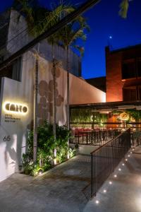 a building with a patio with chairs and palm trees at Canto Hotel in Salvador
