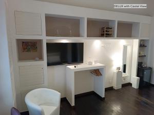 a living room with a tv and a desk with a chair at Dimora Arco Basso - Old Town in Bari +49 photos