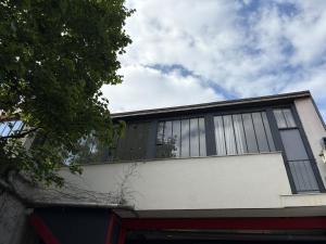a building with glass windows on the side of it at Le Cosy Proche Paris à 5 min Métro & 10 min RER A in Montreuil