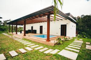 a house with a swimming pool in the yard at Casa de la Cascada in Pedro Vicente Maldonado