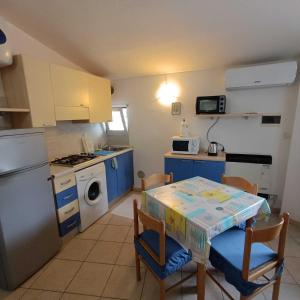 a kitchen with blue cabinets and a table with chairs at Estensi 14 in Lido degli Estensi