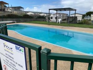 una gran piscina azul con un cartel al lado en ELLA B - caravan park location, en Apollo Bay