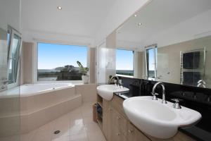 CollaroySpacious Oceanview Escape with Pool and Cabana的一间带两个盥洗盆、浴缸和窗户的浴室