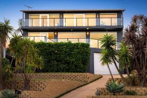 CollaroySpacious Oceanview Escape with Pool and Cabana的一栋门前有棕榈树的房子