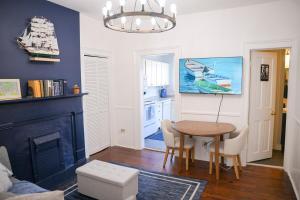 a living room with a table and a kitchen at The Maiden Voyage - Themed Getaway, Steps to Forsyth, King Bed, Grill, Games, Picnic Basket in Savannah +38 photos
