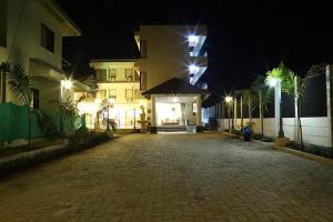an empty cobblestone street in front of a building at night at Sia Resort in Nagaon