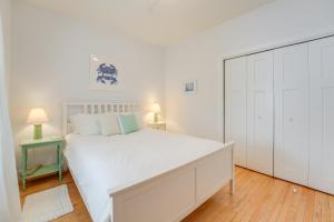 - une chambre blanche avec un grand lit et une armoire dans l'établissement Near Portland Trails Walkable Apartment with Deck, à Portland