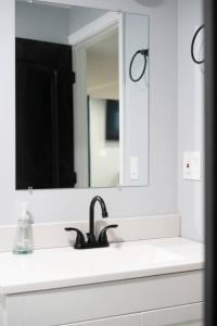 a white bathroom with a sink and a mirror at Urban Contemporary Apartment in Providence