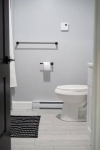 a white bathroom with a toilet and a rug at Urban Contemporary Apartment in Providence