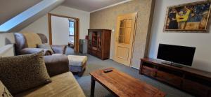 a living room with a couch and a flat screen tv at Vila Jedľa in Starý Smokovec