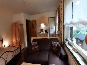 un soggiorno con un divano e una finestra di Ferienwohnung in Wildemann a Wildemann