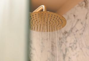 a shower head hanging from a wall in a bathroom at The Lodge Burniston in Scarborough +49 photos