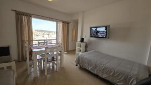 a bedroom with a bed and a table and a desk at La Estadía in Puerto Madryn