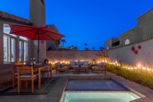 an outdoor patio with a table and an umbrella at Caballeros by ACME House Company in Palm Springs