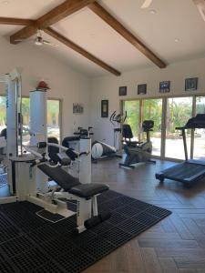 una palestra con diversi tapis roulant e macchine in una stanza di Palazzo del Valle, Alojamiento y Desayuno a Valle de Guadalupe