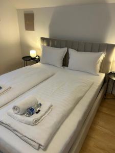 een groot wit bed met handdoeken en een fles erop bij Near airport Zagreb 3, WiFi, Netflix, Self check in in Velika Gorica