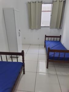 ein Zimmer mit zwei Betten und einem Fenster in der Unterkunft KITNETES Bot in Angra dos Reis