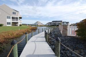 a walkway next to a body of water with houses at Luxurious Bayville Shores Home Close to the Beach! in Selbyville