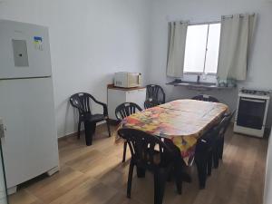 eine Küche mit Tisch und Stühlen und einem Kühlschrank in der Unterkunft KITNETES Bot in Angra dos Reis