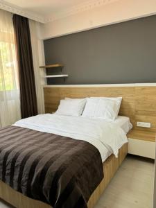 a bedroom with a large bed with a gray wall at Serge Otel in Arapkir