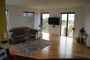 een woonkamer met een bank en een glazen tafel bij Nine Mile Escape in Swansea