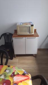 eine Mikrowelle auf einem Tisch mit einem Stuhl in der Unterkunft KITNETES Bot in Angra dos Reis