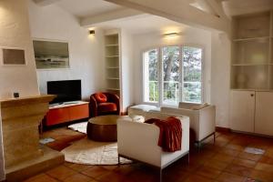 Una sala de estar con muebles blancos y una gran ventana. en Villa Luxe avec Vue sur Saint-Tropez, Roquebrune, en Roquebrune-sur-Argens
