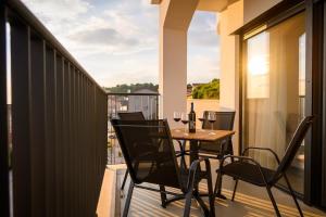 a balcony with a table and chairs on a balcony at Apartments Sunset Komarna in Komarna