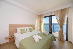 a bedroom with a large bed with two pillows on it at Apartments Sunset Komarna in Komarna
