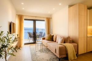 a living room with a couch and a balcony at Apartments Sunset Komarna in Komarna