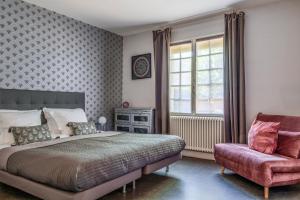 a bedroom with a large bed and a chair at La Villa Pop in Joue-les-Tours
