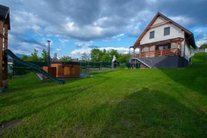 a playground with a house and a slide at Chata Závažka in Závažná Poruba