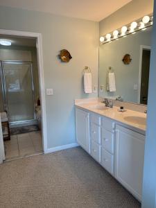 une salle de bain avec deux lavabos et un grand miroir dans l'établissement Bayville Shores Water View - 3 bedroom home close to beach!, à Selbyville 29 autres photos