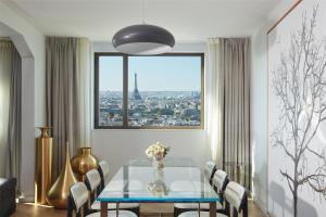 a dining room with a table and a view of the city at Hyatt Regency Paris Etoile in Paris