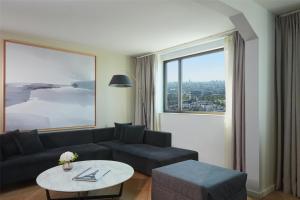 a living room with a couch and a table and a window at Hyatt Regency Paris Etoile in Paris