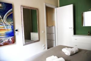 a bedroom with two mirrors and a bed with towels at Lungomare Urban in Pescara