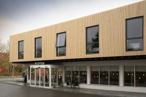 a large building with windows and tables in front of it at Four Points Flex by Sheraton Copenhagen Airport in Copenhagen
