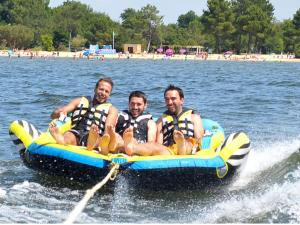 three men in life jackets on a raft in the water at Bungalows climatisés en 3 ou 4ch - jusqu'à 18 voyageurs - mh732 3ch ou mh828 4ch Biscarrosse Lake-proche océan in Gastes